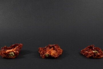 some dried tomatoes on a black background