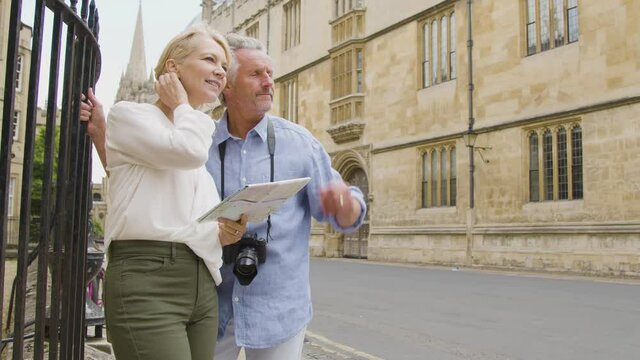 Medium Panning Shot of Middle Aged Couple Reading a Map