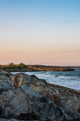 Rocky beach and waves crashing at sunset