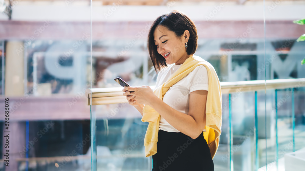 Poster asian female blogger with cellphone device searching information while networking internet via mobil