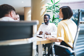 Delighted black man at meeting with coworkers