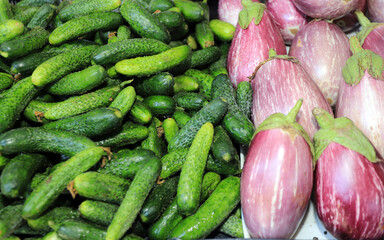 Raw gherkins (pickles) and two colored eggplants.