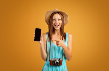 Excited girl tourist pointing at blank mobile phone screen