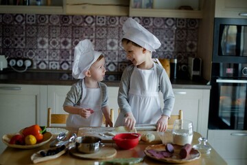 children preparing pizza in the kitchen