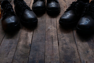 pair of black leather shoes,3 pairs of leather safety shoes placed on a vintage wooden background.