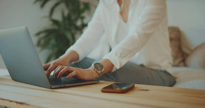 Professional young woman types on computer while working from home, social distancing