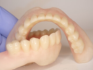 Dentist hold cheap kind of set of dentures for senior