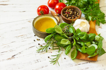 Ingredients for cooking. Herbs spices, olive oil and vegetables on a wooden table. Copy space.