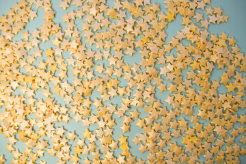background consisting of yellow confetti stars scattered on a blue background