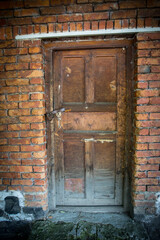 old door of brick building close up. The red brick wall and wooden door shot