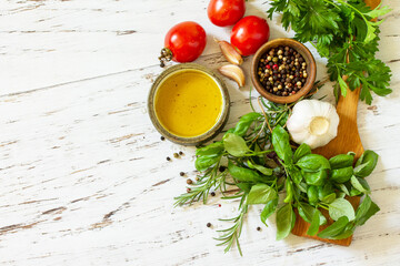 Ingredients for cooking. Herbs spices, olive oil and vegetables on a wooden table. Top view flat lay background.