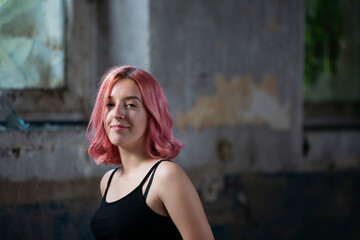 Obraz na płótnie Canvas Young funky teenage girl with pink hair in abandoned building.