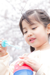 Naklejka premium シャボン玉で遊ぶ女の子