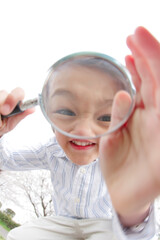 虫めがねで覗く男の子