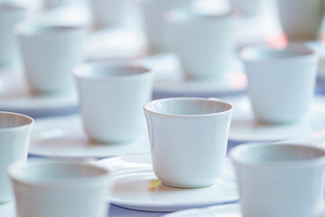Obraz na płótnie Canvas Many rows of white ceramic coffee or tea cups and saucers.