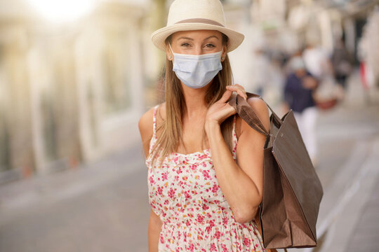 Young Woman Doing Shopping In Tourist Area, Wearing Face Mask