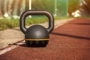 Fototapeta na wymiar Kettlebell standing on rubber coating surface of outdoor workout ground