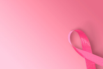 Pink awareness ribbon on pink background