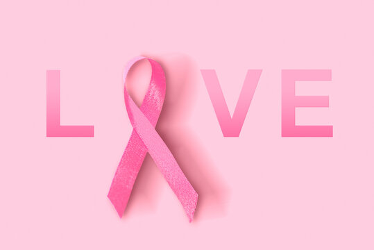 Pink awareness ribbon with LOVE text on a pink background