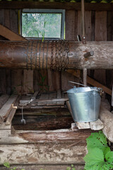 An old village well, with a metal bucket, on a summer day, in Russia. Close-up, vertical format.