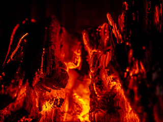 Charcoal in the fire. Close-up shot of hot flames and glowing coals. Red and black colors.