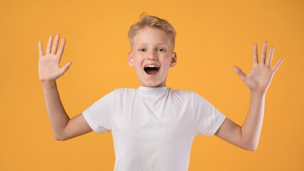 Little guy celebrating over yellow studio background