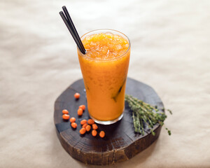 sea buckthorn lemonade on a wooden stand in a glass glass