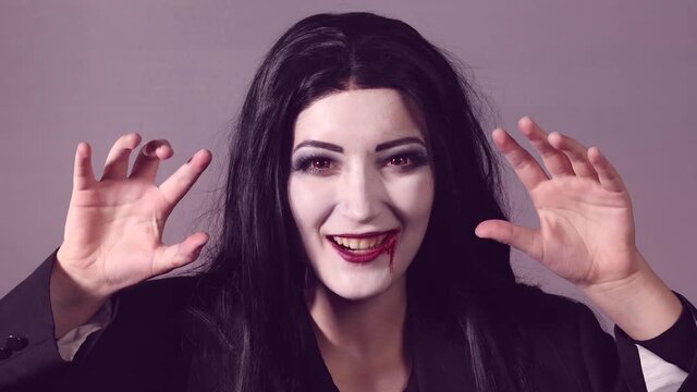 Young woman with halloween makeup doing scary move