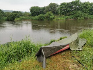 Kanutouer auf dem Fluss im Regen
