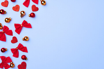 Winter festive background with hearts, bows and baubles