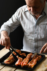 Selective focus. The chef places the marinated pork ribs on a baking sheet. Cooking the ribs.