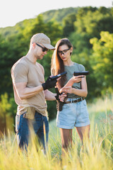 the instructor teaches the girl to shoot a pistol at the range