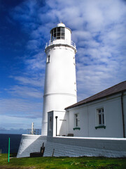 The white Trevose Head lighthouse stands against a  background Near the town of Padstow on the North Cornwall coast