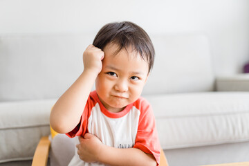 Angry kid.Little asian boy looking at his mother and fighting with mom.Furious hungry toddler kid got upset and sad and he has a negative attitude.Depressed little toddler boy complaining.Ef in Kid.