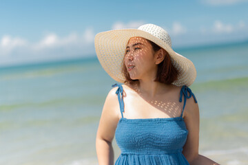  asian woman in blue dress in summer on the sand on the beach of tropical island.