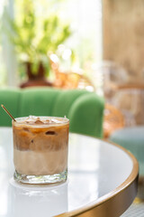 Ice coffee in a tall glass with milk poured over