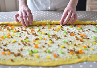 female hands twist the dough with raisins and candied fruits. raw cake dough