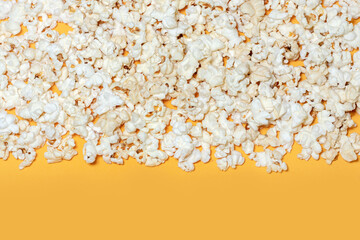 Tasty salted popcorn on yellow background.