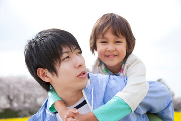子供をおんぶする父親