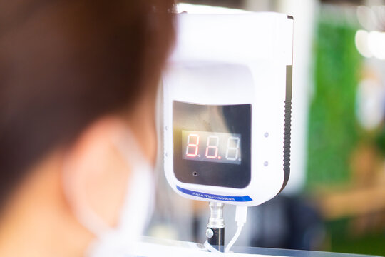 Disease control experts use an Infrared thermometer equipment to check the auto temperature on the forehead and use alcohol gel to screen the patients addicted to Covid before entering the building.