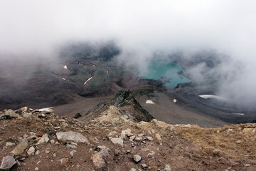 Alpine lake in the clouds. Alpine lake with rocky shores and emerald water in the clouds. Alpine lake Giybashkel (3240 meters above sea level), Caucasus. View from Yakov Pass.