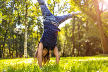 Child doing hand stand in park
