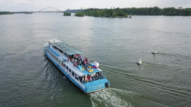 a flying camera chases a passenger boat on the ob river in siberia