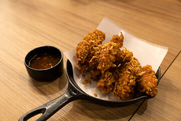 Vietnamese sesame fried chicken wings with dipping sauce on a wooden table