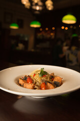 salmon pasta on wood table with blur irish pub style background