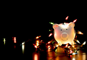 White piggy bank with Christmas string lights on happy December festival, Enjoy savings for...