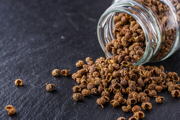 Sichuan pepper on a dark stone background