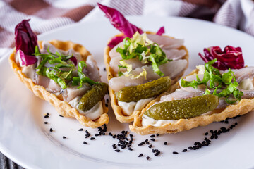 delicious snack tartlets on rustic wooden background