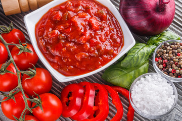 Fresh tasty tomato sauce on rustic wooden background