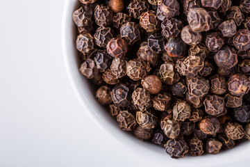 fragrant black pepper on white acrylic background